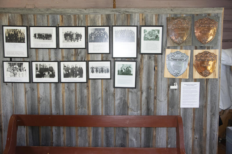vegg med gamle bilder og plaketter fra skoleutstillingen i Vingelen gamle skole