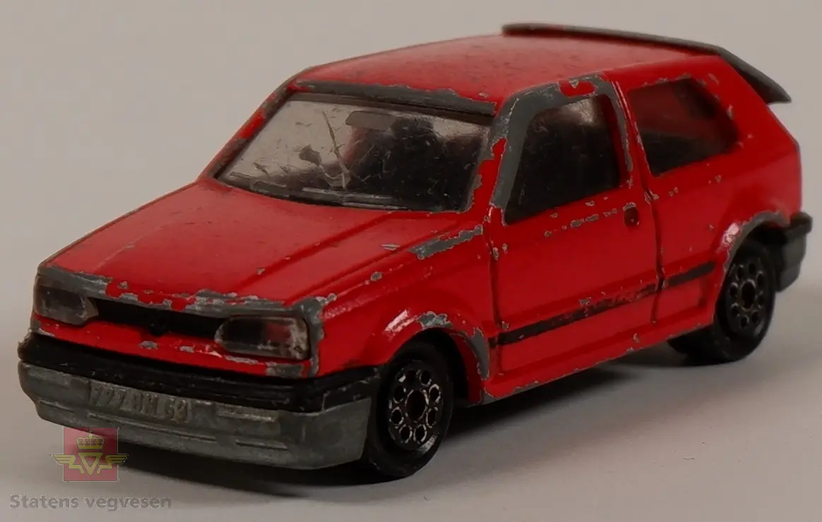 Modellbil av en Volkswagen Golf, modellbilen er farget rød. Skala 1:56