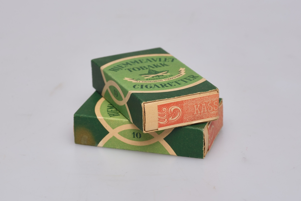 Sigaretter, 2 pakker. Grønn rektangulær eske påtrykket: HJEMMEAVLET TOBAKK CIGARETTER. 10 stkr  Avgift kr 0,40. Produsert av J.L. Tiedemanns Tobaksfabrik,
