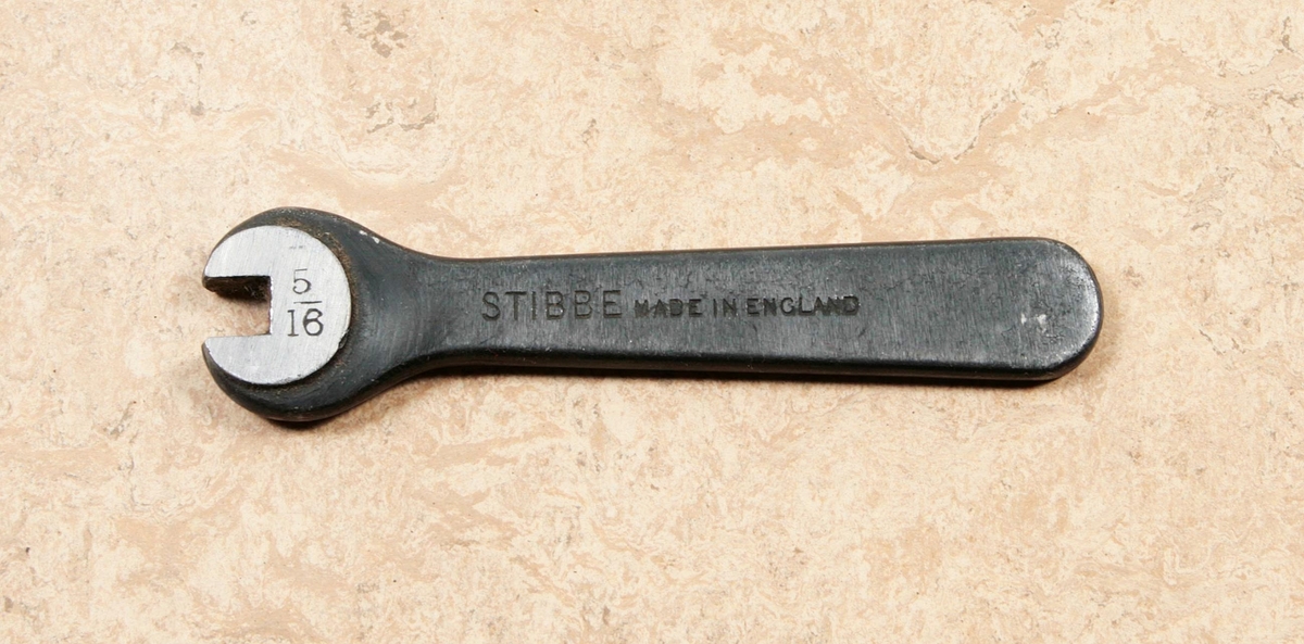 Fast nyckel av stål. Enkel U-nyckel. Märkt: 5 / 16, STIBBE MADE IN ENGLAND. Proveniens Fritz Sjöbloms Trikåfabrik, Borås.