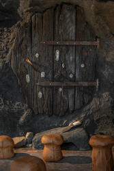 Trolldøren i Eventyrkroken. Døren sitter i en stor stein og har gamle nøkkelhull over hele seg.