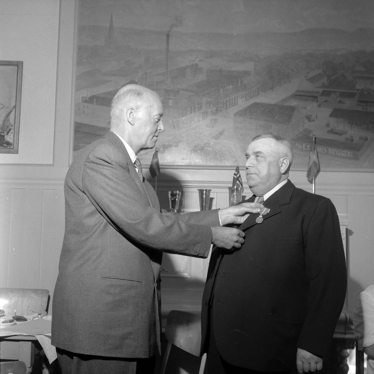 Vaktmester Alfred Halvorsen tildeles H.M. Kongens fortjenstmedalje for 50 år ved E.C. Dahls Bryggeri av direktør O.K. Lysholm