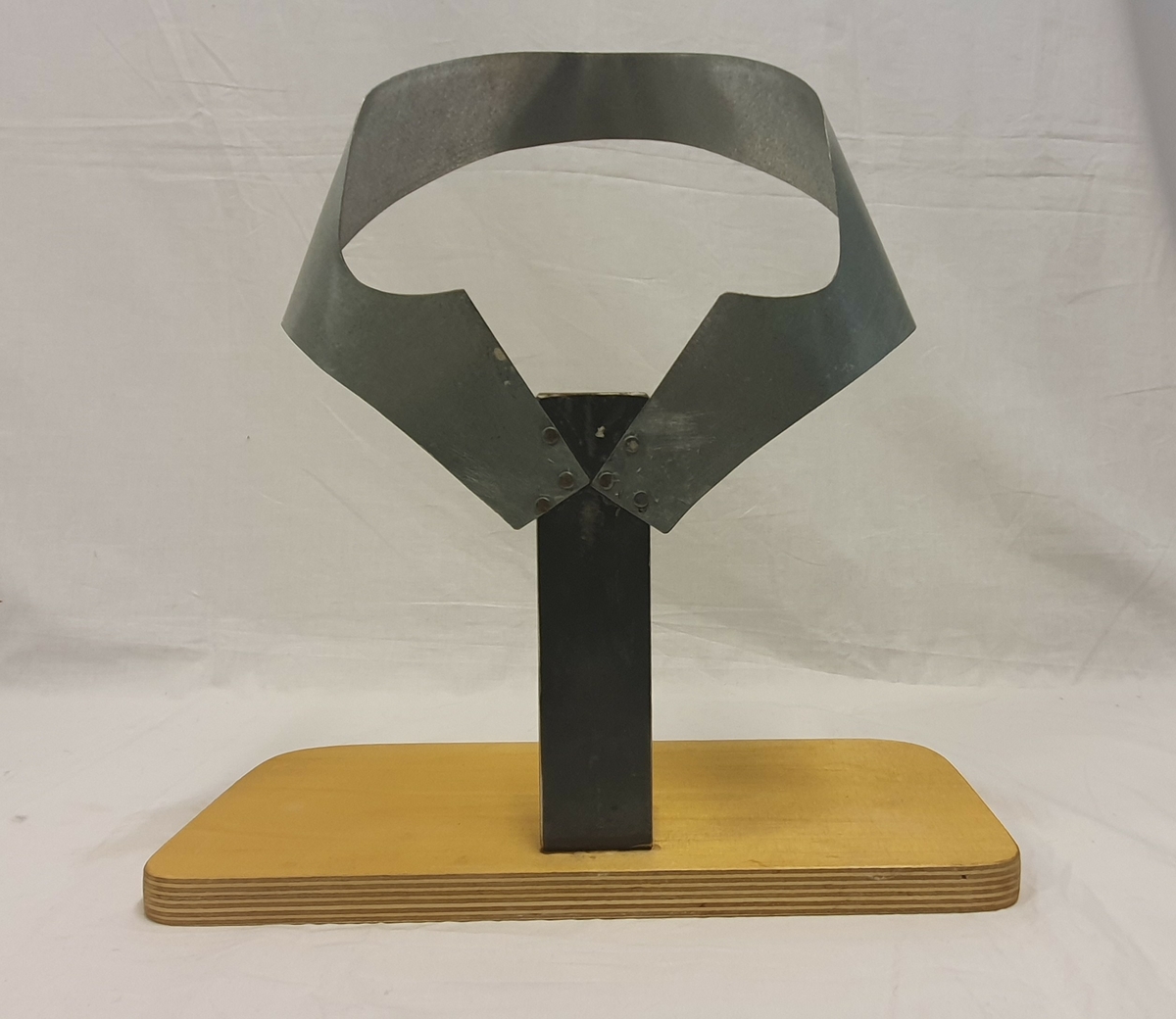 Stativ laget av givers ektefelle; Olav Solvang. Stativet brukes til å forme bordpapp til valk. Bordpapp settes i stativet for å tørke og få formen.