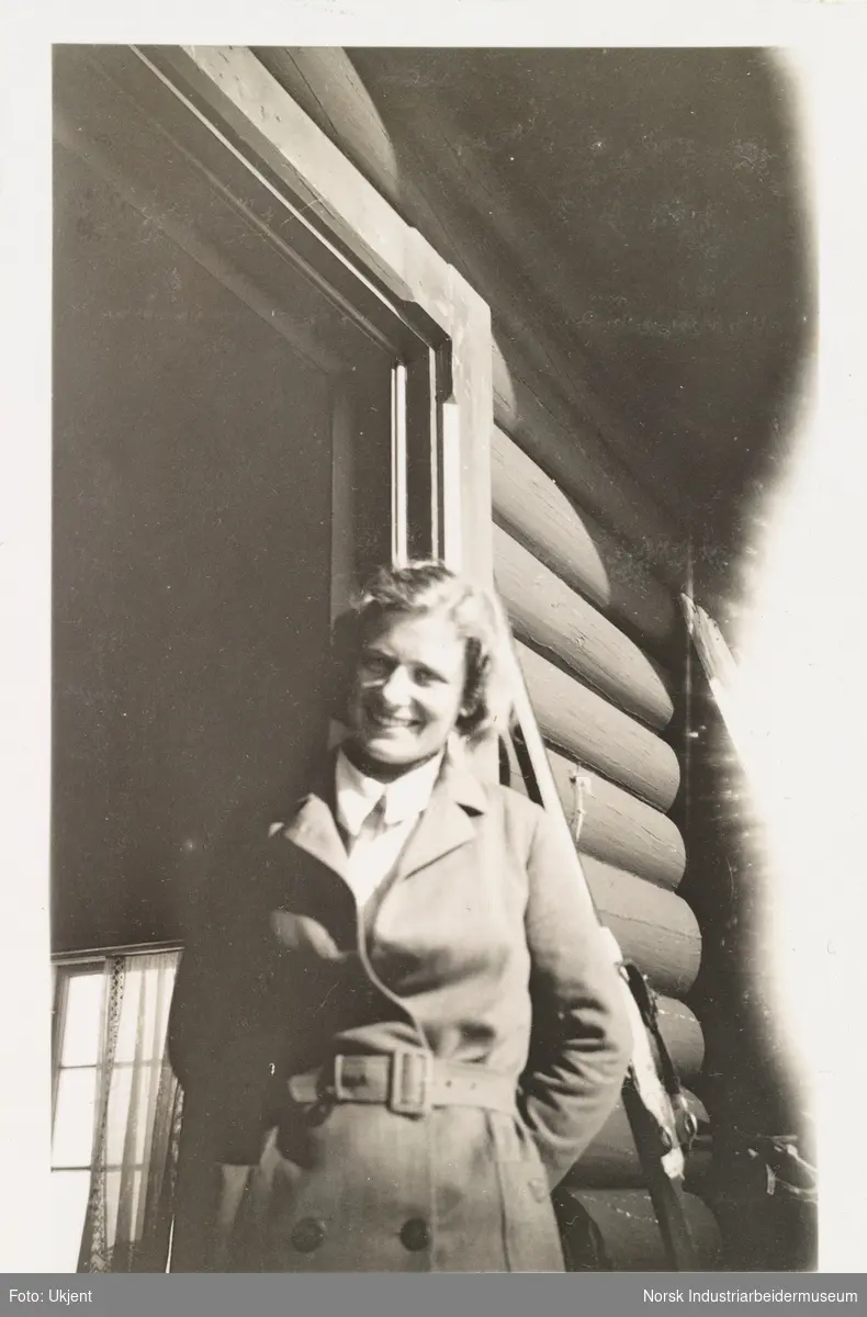 Fagerli, påske 1931. Kvinne står i døråpning på laftet hytte.