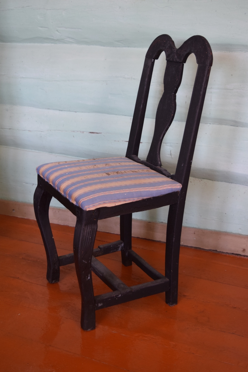 Sortmalt stol i bonderokokko uten armer. Trekket er i hjemmevevde farger.