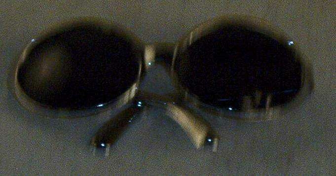 Solbrille med innfatning i sølvfarget lettmetall.