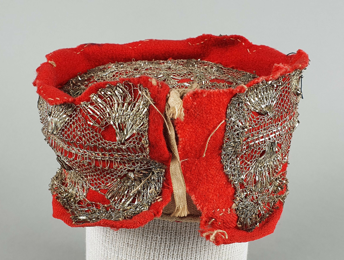 Valk for brudepike trukket med rød ull og påsatt en bred sølvblonde av metall. Det er også sølvblonde på toppen som er noe lavere en kanten rundt. Valken knyttes sammen midt bak med to snorer av bomull.