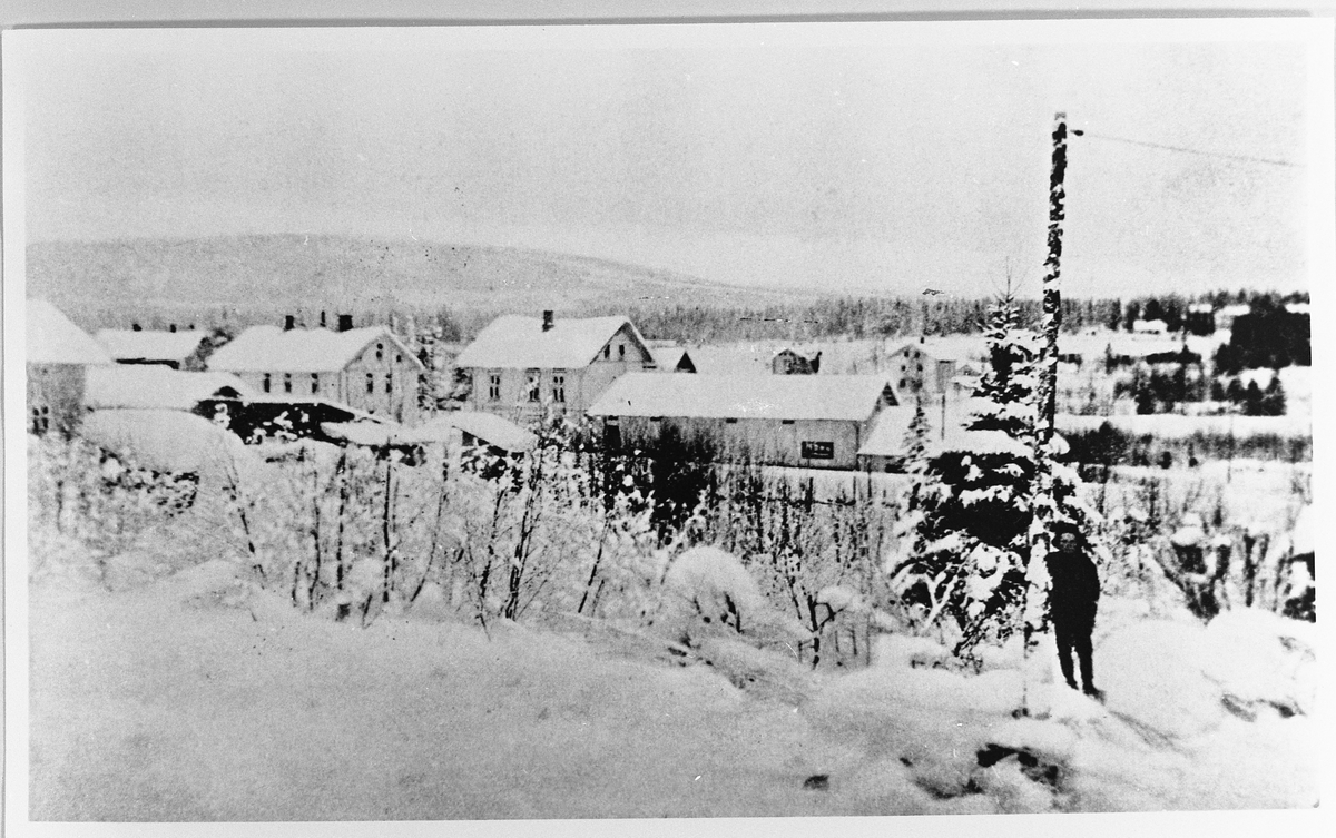 Raufoss sentrum ca. 1912. Bildet er tatt fra jernbanelinja mot Torvet. Vi ser bakeriet og Rødfosbutikken med det lange lagerbygget. Bakenfor noen av husene på Raufoss Gård. Skolene er ikke bygd.