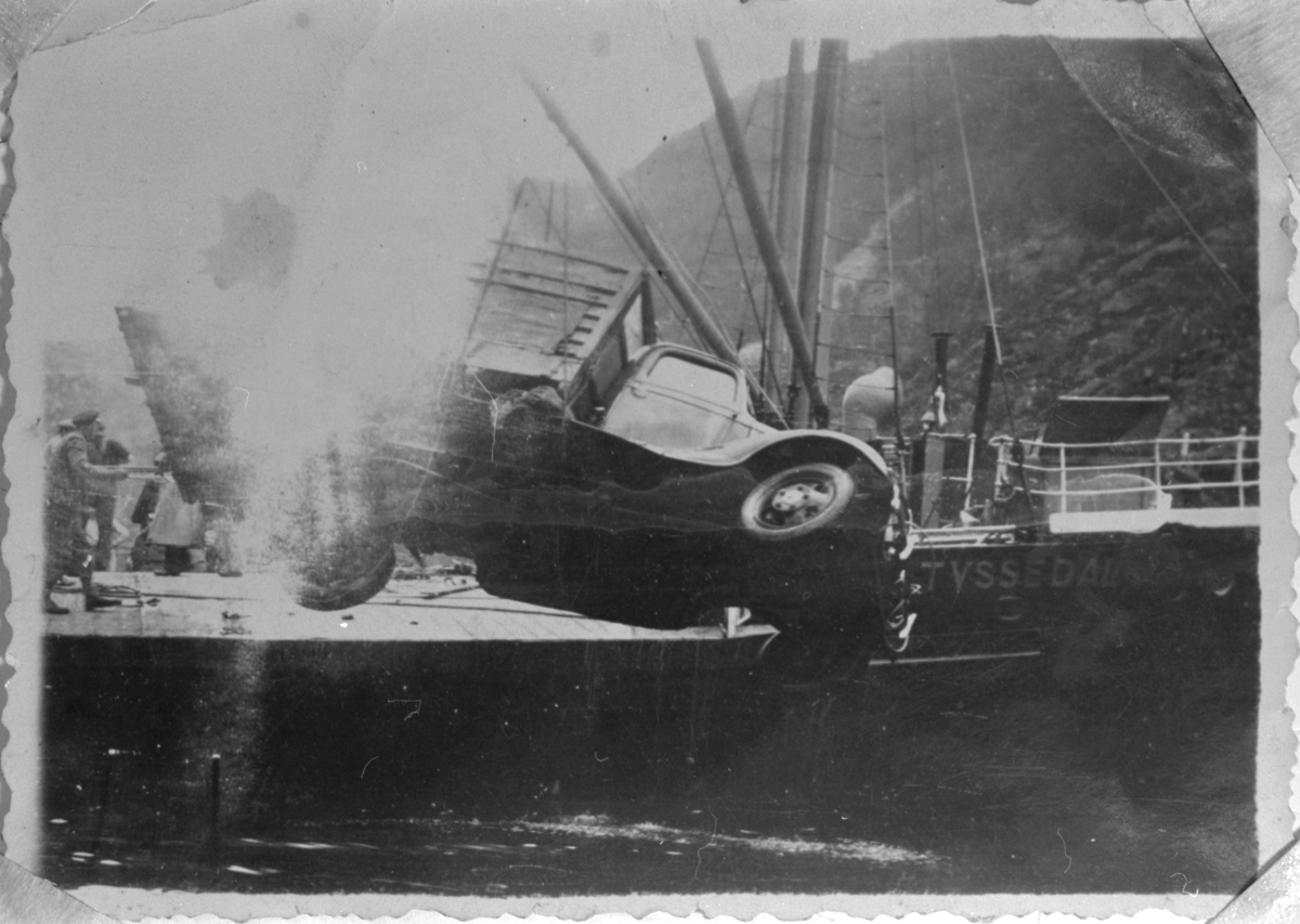 Alv Vilands lastebil vert henta opp av sjøen på Fjæra i Etne, 1937. I bakgrunnen er HSD si ferge "Tyssedal".