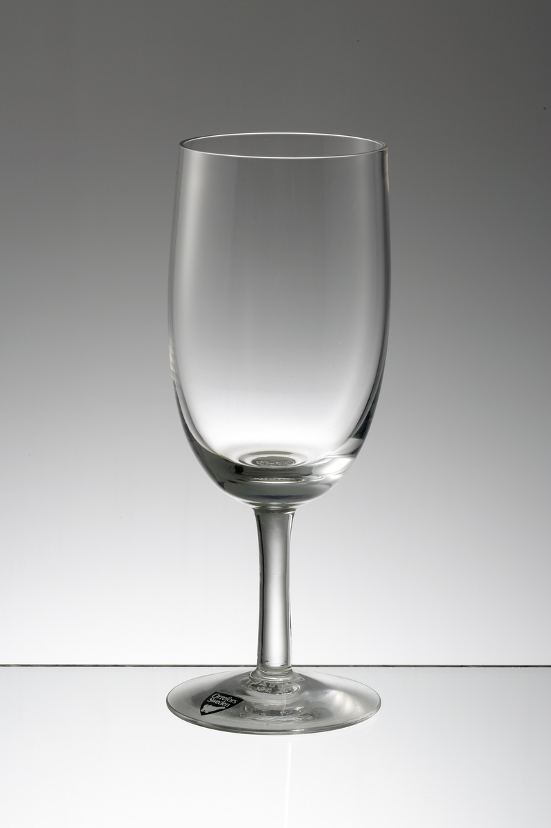 Design: Nils Landberg.
Ölglas. Ovoid slät kupa med stråben.
Fabriksmärke: mörkgrå botten med vit text.
