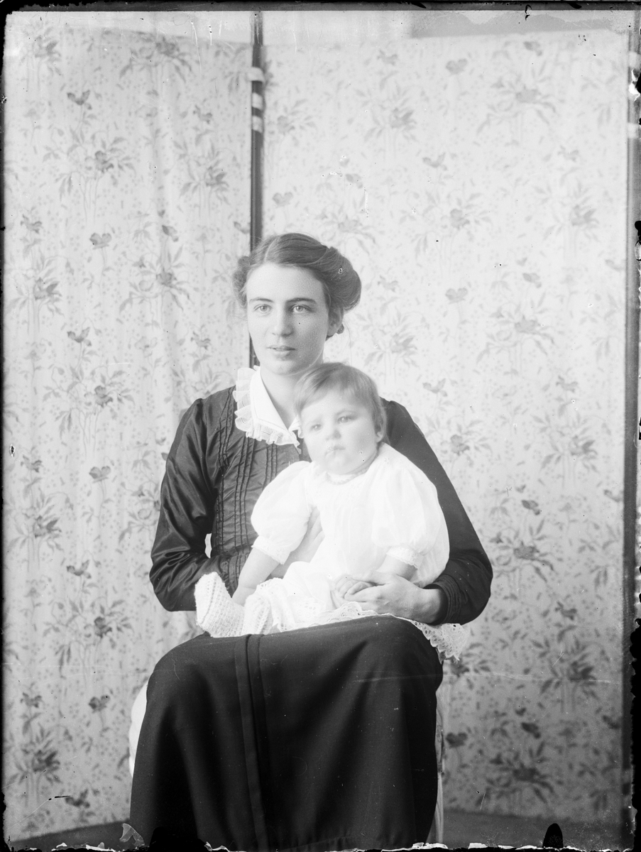 Kvinna med litet barn i knät, Östhammar, Uppland