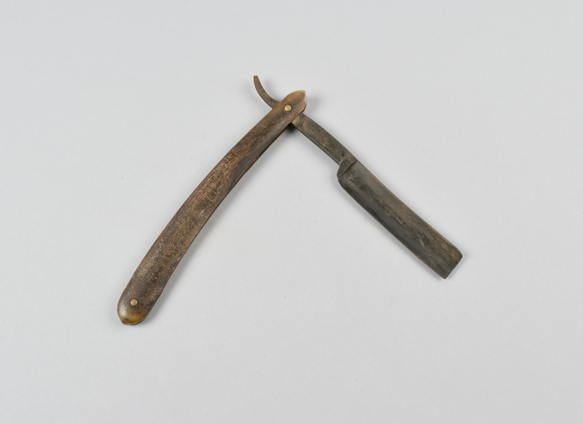 Sammenleggbar barberkniv med stålblad, skaft i horn, holk i messing.