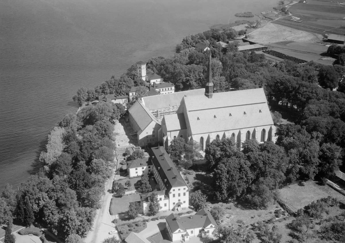 Flygfoto över Vadstena medeltida kloster med klosterkyrka som dominerande byggnad.