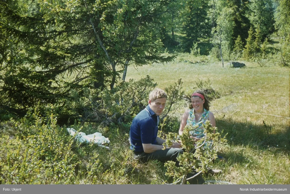 Anne og Bjørn Dyrland sitter i gresset i Åmotsdal