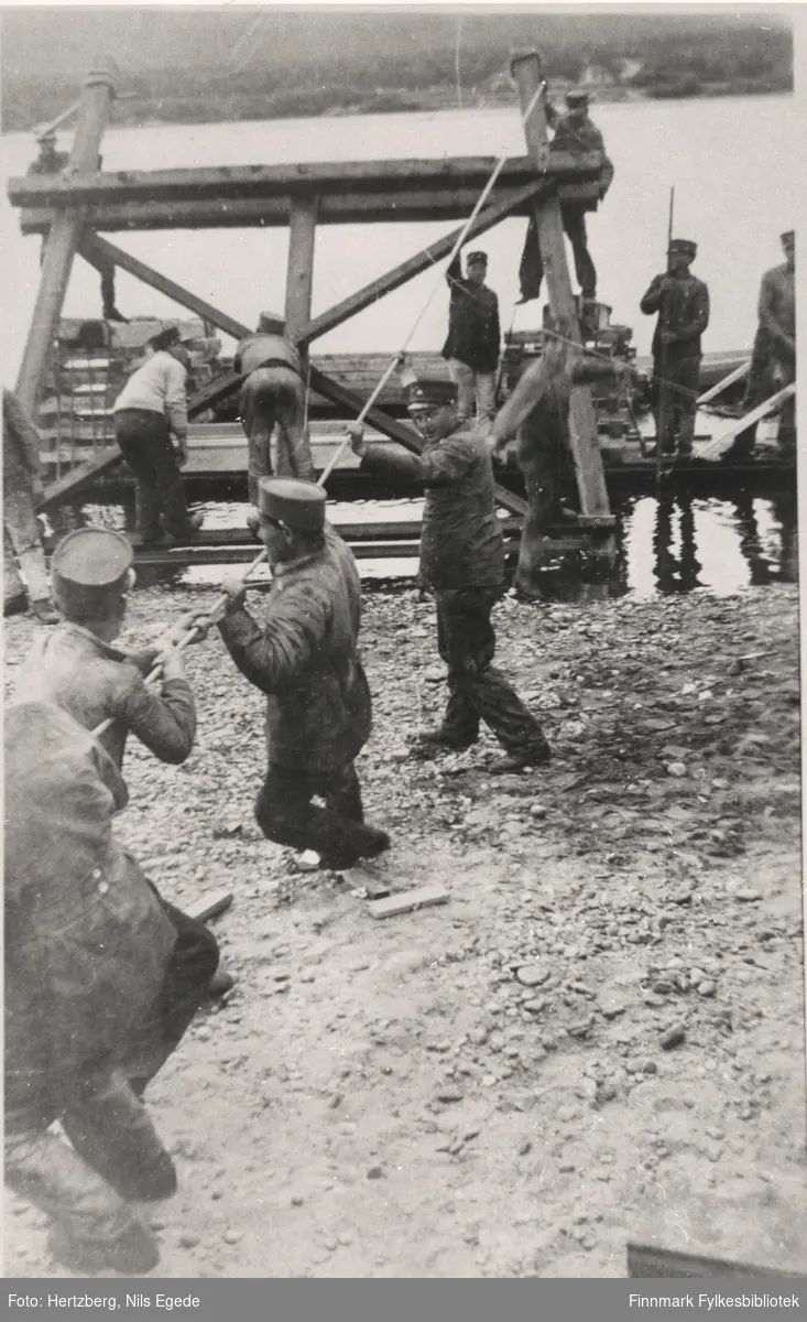 Brubygging over Tanaelva. Fem menn frakter bukkene ut på Tanaelven på en flåte. Seida-Tana, 1939.