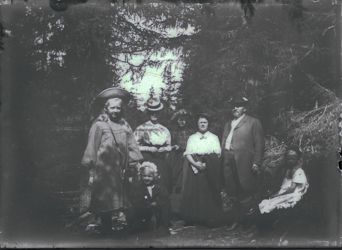 Familien Rydgren på skogstur. De står i gammel granskog.