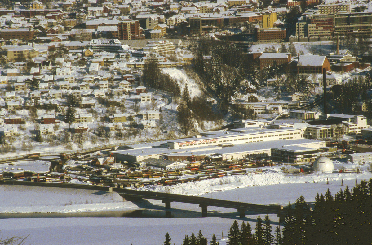 Lillehammer. Nedre bydel, Strandtorget, Lillehammer bru og Gudbrandsdalslågen. Strandtorget ble brukt som bussterminal under OL 1994. Utsikt mot øst fra Saksumsdalsvegen.