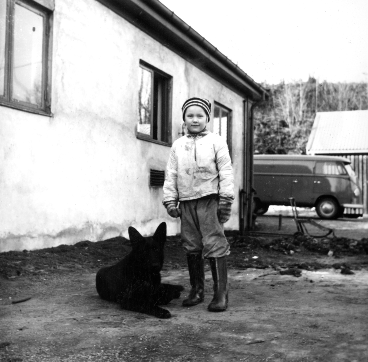 Else Marie Larsson, datteren til overgartner Gösta Larsson, med hunden Tarzan utenfor fyrhuset til gartneriet på Bygdø Kongsgård, 1957.