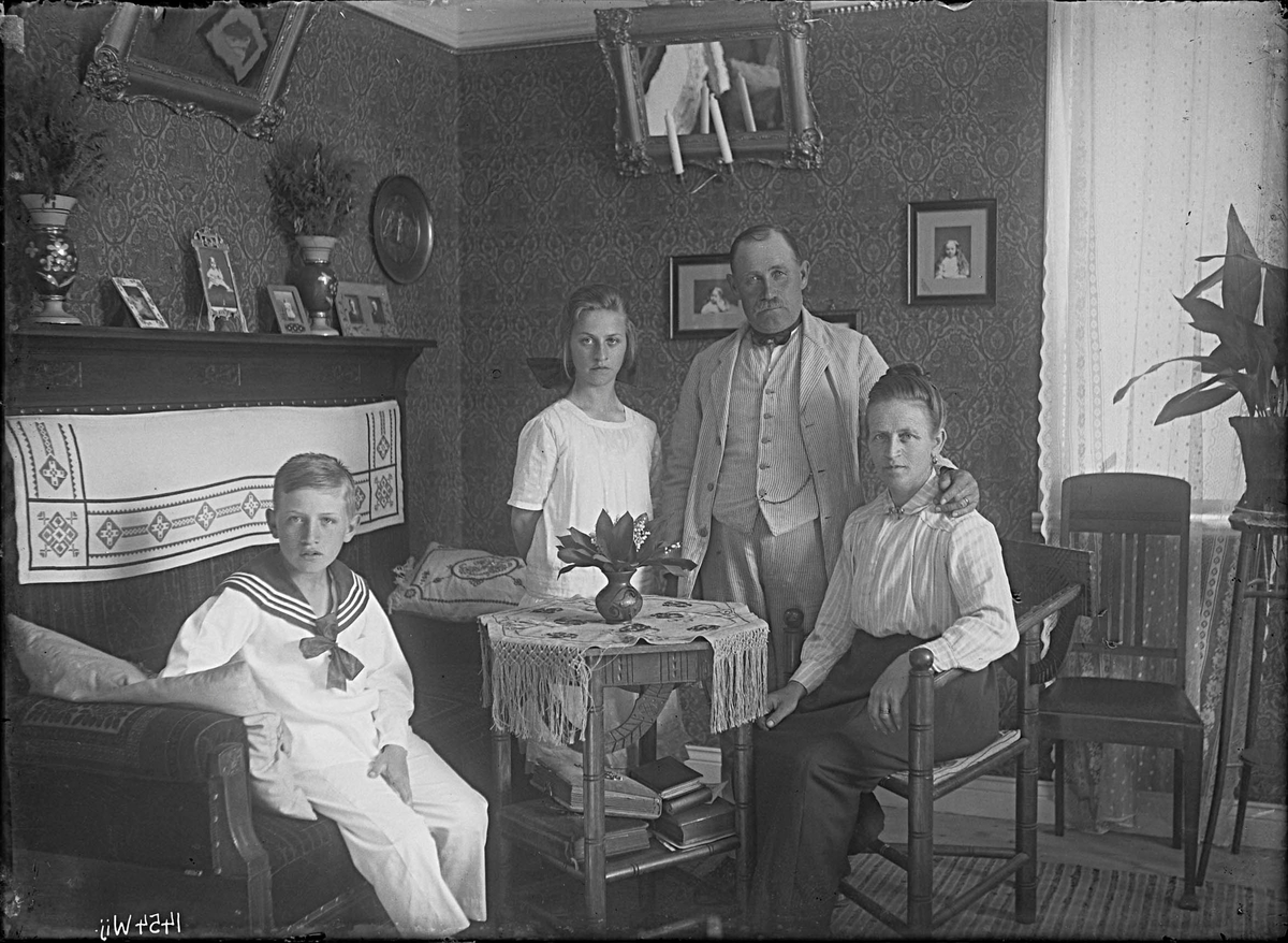 Fotografering beställd av Adolf Pettersson. Föreställer sannolikt Gustaf Adolf Pettersson (1868-1946) med hans hustru Anna Sofia Jädersten (1874-1959) samt barnen Anna Helga (1904-1992) och Gustaf Helge Kävsten (1910-1982).