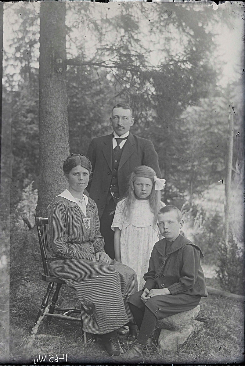 Fotografering beställd av Gustafsson. Föreställer sannolikt arrendator Emil Valentin Gustafsson (1883-1937) och hans hustru Elna Josefina Johansson (1891-1974) samt barnen Sven Fabian (1910-1936) och Elna Margareta (1912-1997).
