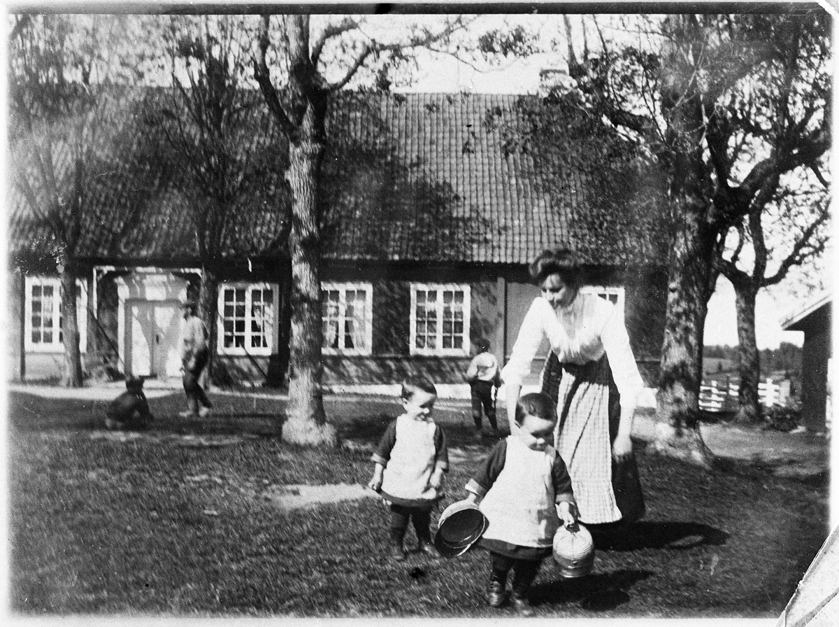 Fra gården Evenrud på Kapp ca. 1910
Paulie Hveem (f.Raabe) med tvillingene Arne og Thor (Thoralf) Raabe. I bakgrunnen, ved huset til høyre, står Sverre Raabe.