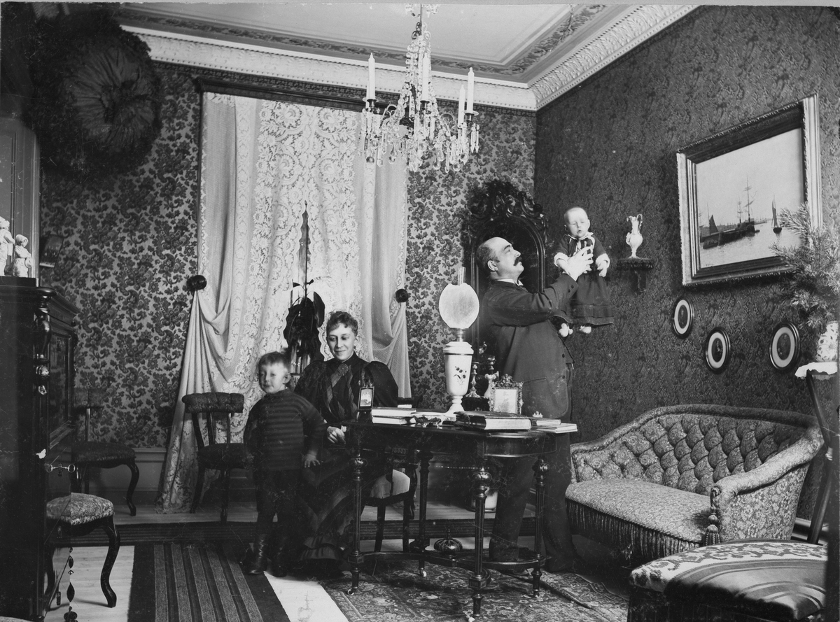 Interiör, man håller barn. Foto 1962 efter foto Georg Åkerlöf, Stockholm omkr 1895