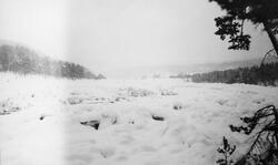 Tømmer under snø og is i Eidsfossen i Glomma, vinteren 1926.
