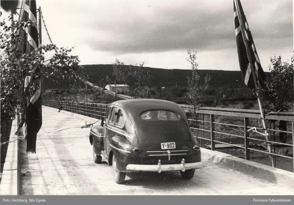 Åpningen av Tana bru i august 1948. Fylkesmannen Peder Holt er med i bilen (Y-902 er en amerikansk Ford 1946) som kjører først og snoren blir brutt. Se også de andre åpningsbildene 346-358.