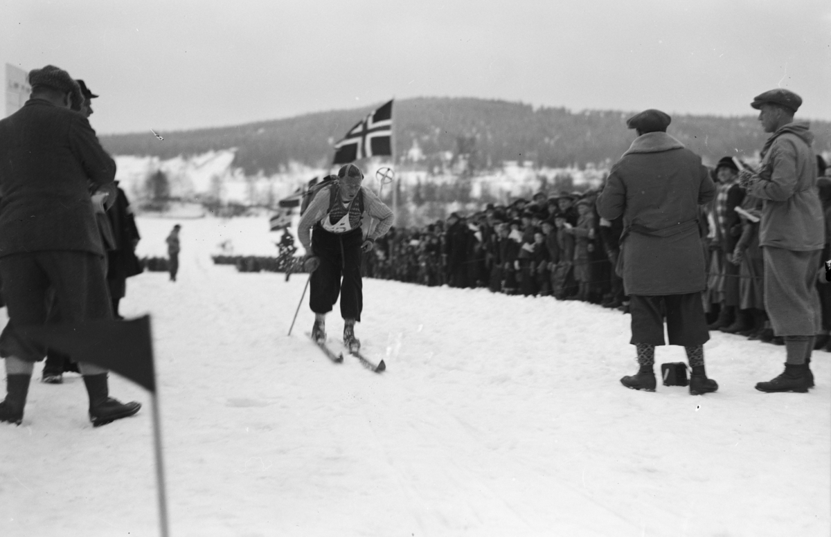 Birkebeinerrennet, en løper på veg mot mål på Lysgårdsjordet i Lillehammer, tilskuere og arrangører følger med.