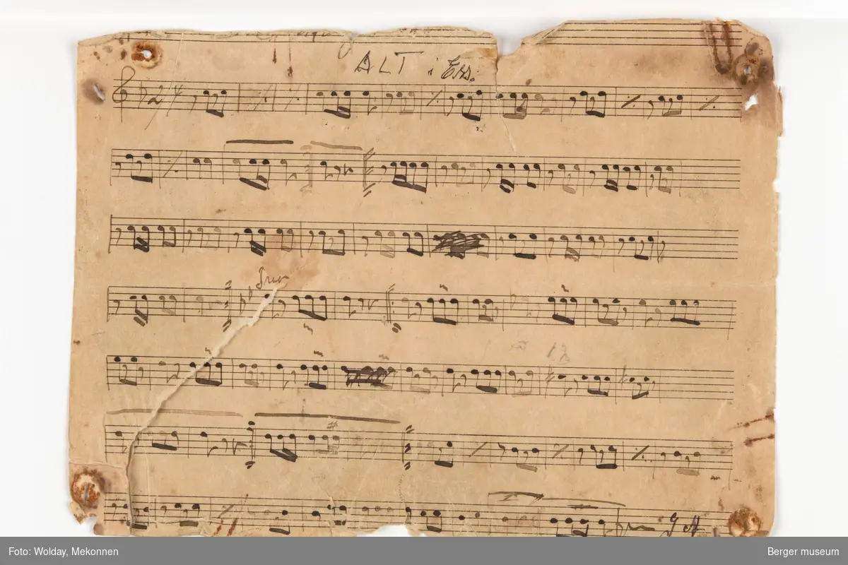 Håndskrevne noteark til "Hardanger marsj ". Det er seks noteark i med noter til forskjellige instrumenter. Arkene er trykt med notelinjer, mens notene er håndskrevne.