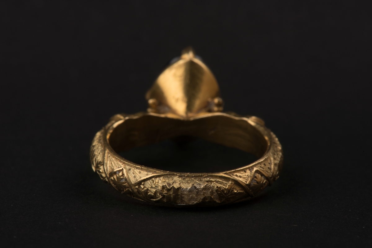 Ring av guld med oval safir.
Safiren vilar i konisk fattning med fyra gripklor. Ursprungligen var troligen ringen belagd med emalj. Ringens utsida har bokstavsfält med betydelsen "safiren vakar över Eder".