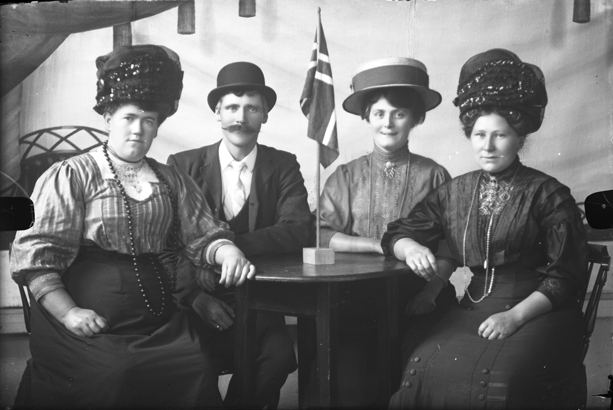 Portrett av tre kvinner med flotte hatter og en mann