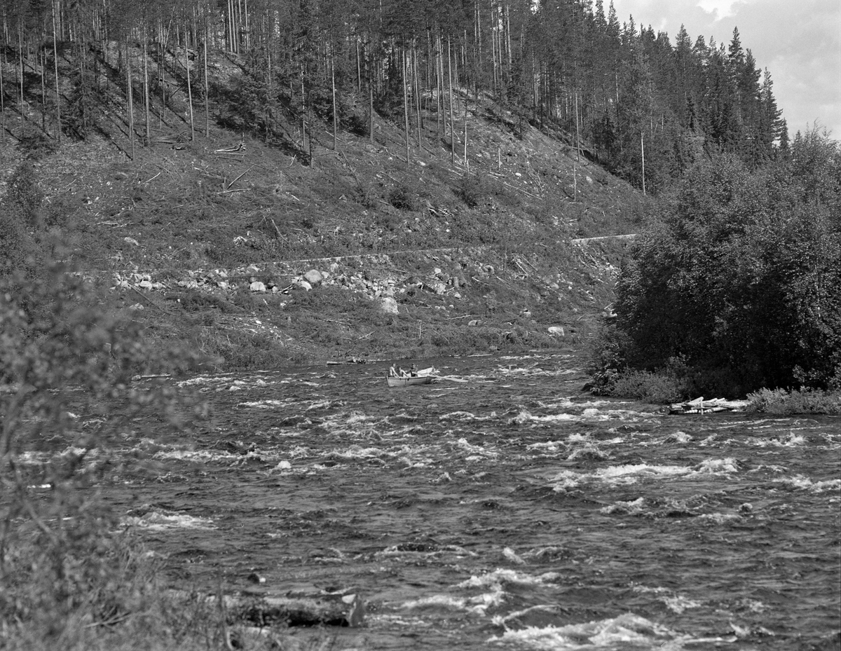 Sluttrensk i elva Stor-Grøna i Trysil, Hedmark. Fløtere på veg ned elva i robåt.