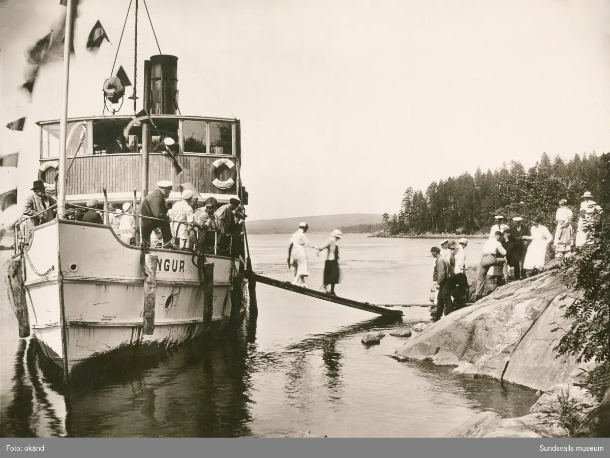 Ett sällskap på tur med skärgårdskryssaren Angur, troligen någonstans i Höga kusten eller Ångermanälven. Båten trafikerade Härnösand– Sollefteå, tog 236 passagerare, hade en god isbrytande förmåga och användes ibland även som bogserbåt.