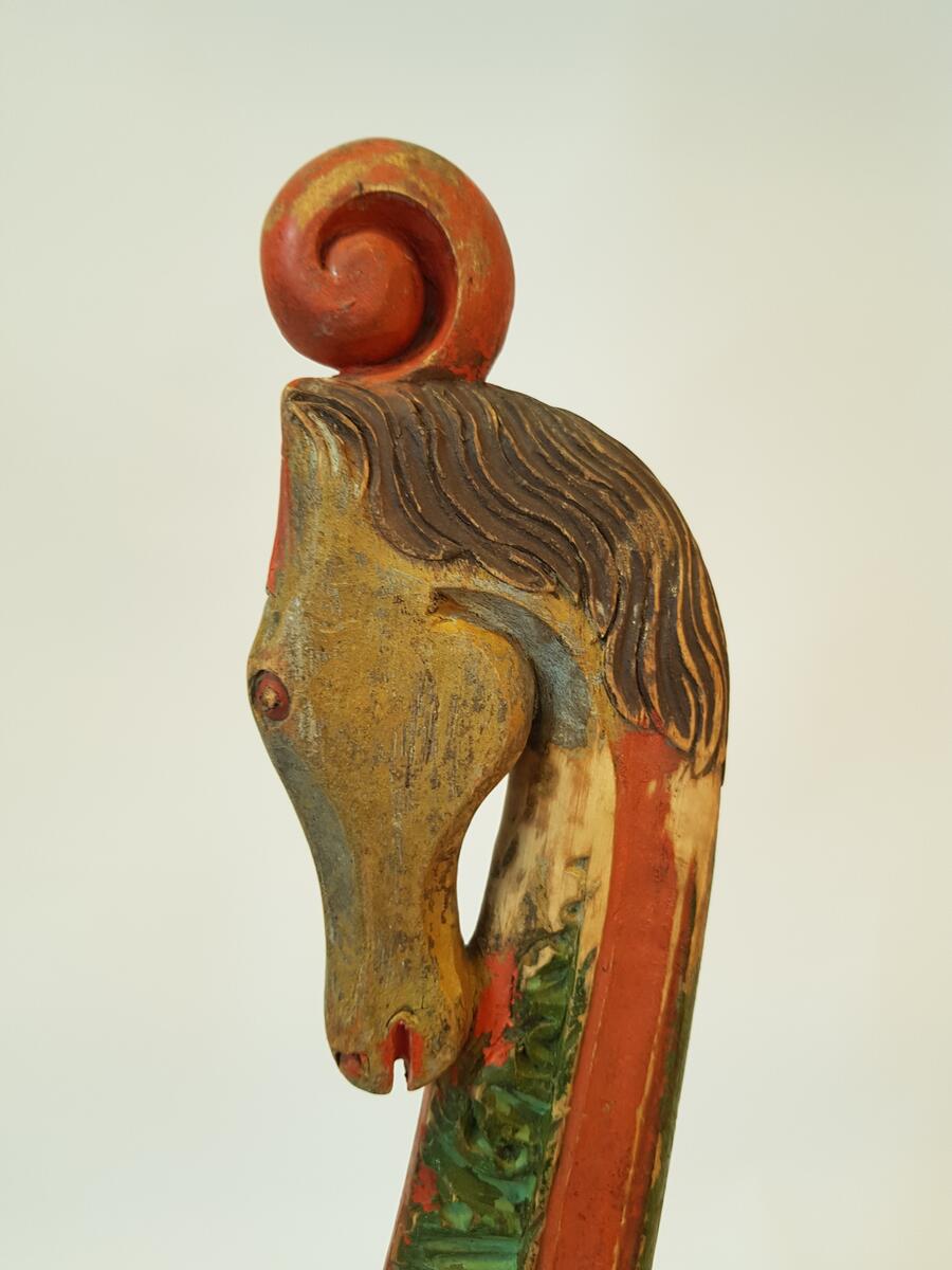 Lokor, ett par, av trä. Målade i rött, grönt, brunt, vitt och blått. Rikt skulpterade med akantusblad, upptill med hästhuvuden. Rörliga dragläderskrampor.