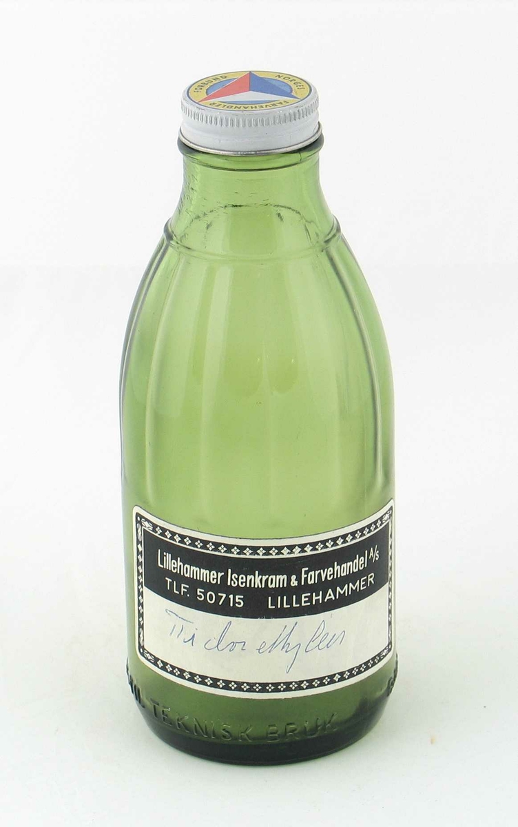 Flaske av grønt glass, med hvitfarget skrukork av blikk med flerfarget logo på toppen.