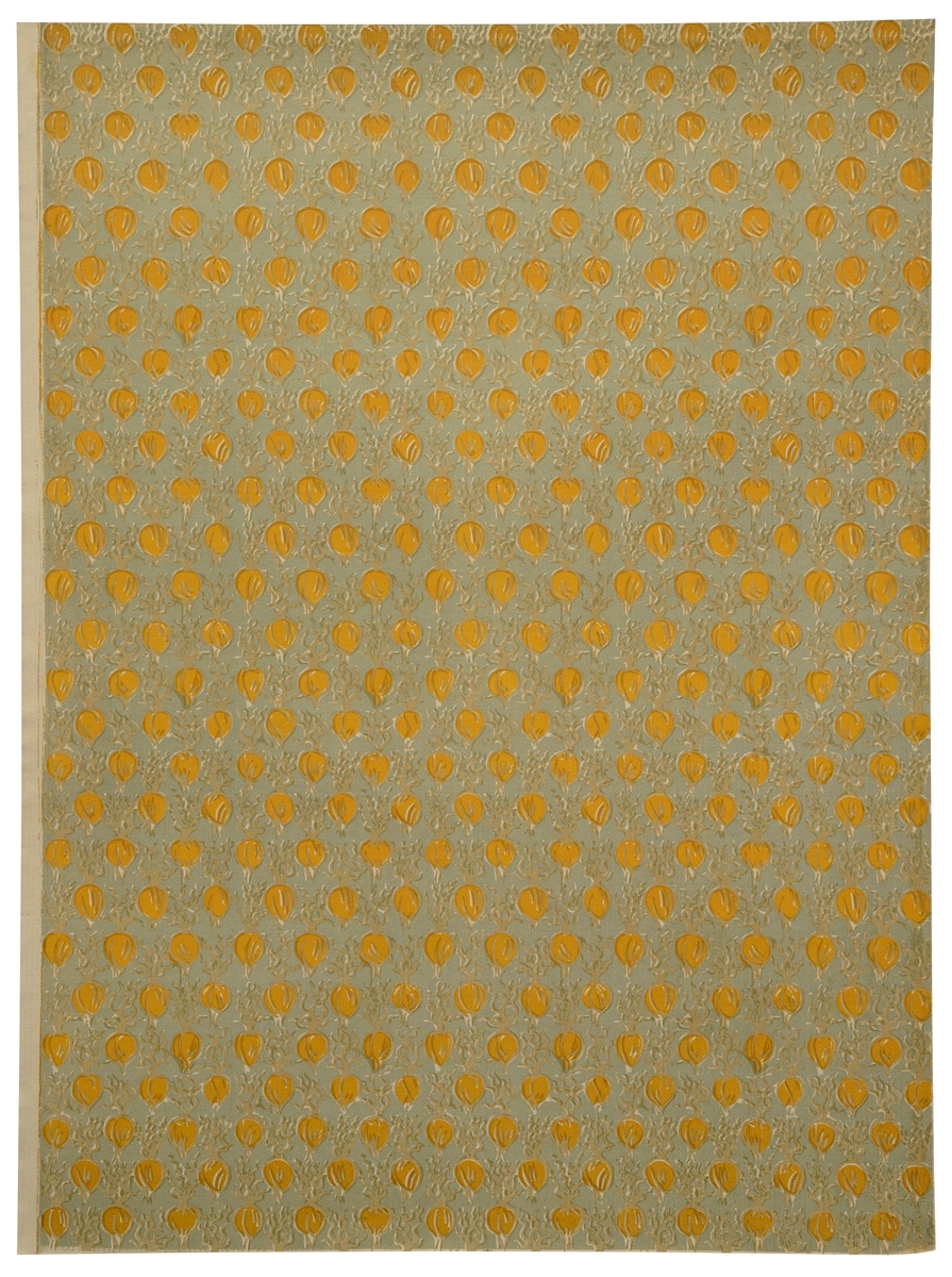 Rektangulært dekorativt papir med mønsteret "Spirende lög". Forsiden er dekorert med et repeterende mønster av stiliserte løkformer i oker - omgitt av beige konturlinjer - på blågrå bunn.