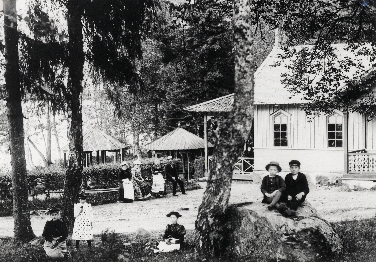 Evedals hälsobrunn på 1880-talet. Några personer i olika åldrar har samlats utanför dåv. brunnssalongen.