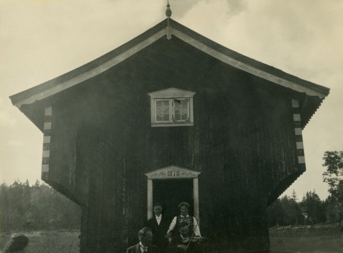 Brudeparet og spelemanen Einar Lund kjem ut frå stabburet på Torstveit under Gunhild og Georg Grosvold sitt bryllaup 28.8.1926