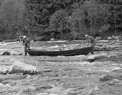 To tømmerfløtere med en båt i Klokkerfossen, på østsida av P