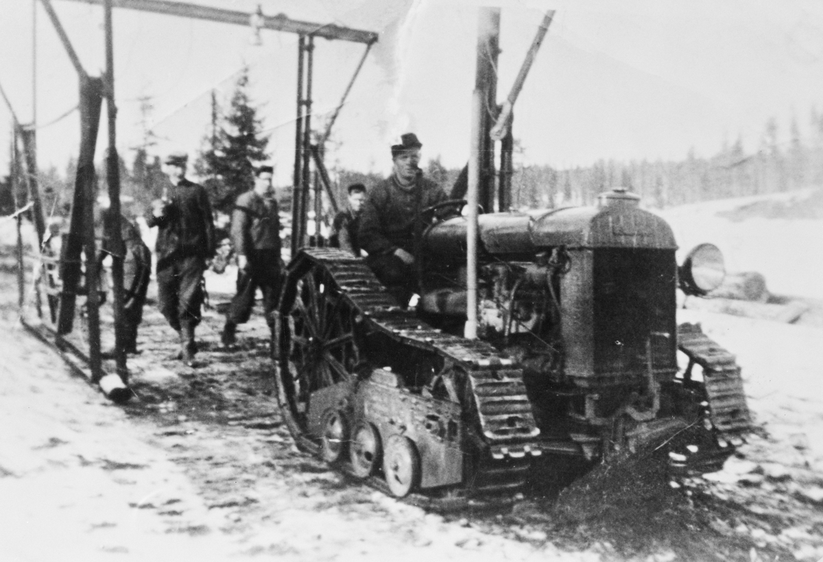 Skogsdrift på Flishøgda, Elverum, Hedmark ca. 1938. Fordson m. helbelter står foran et spesielt lastestativ, muligens konstruert for å laste tømmer på tømmerbiler.