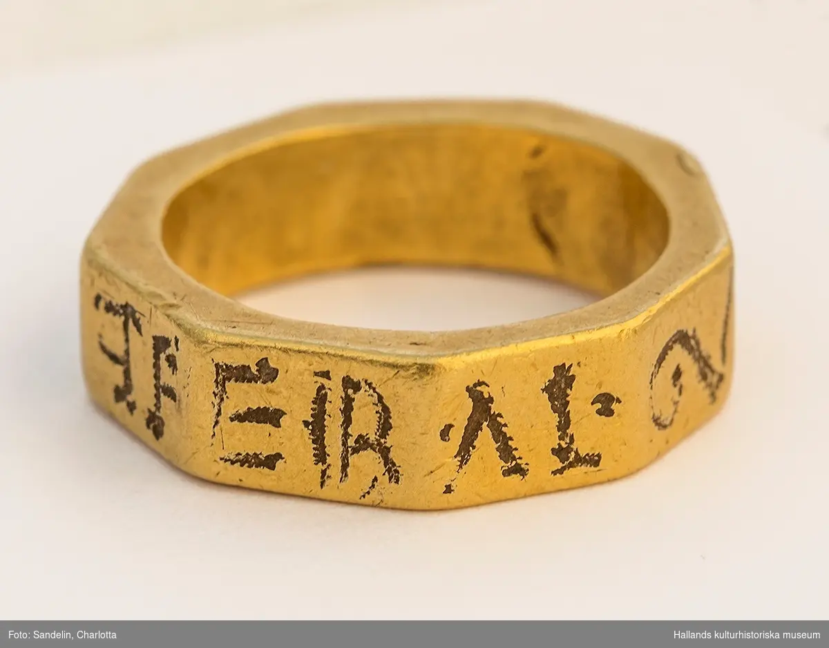Nioktantig guldring med en präglad inskription på ringens utsida.