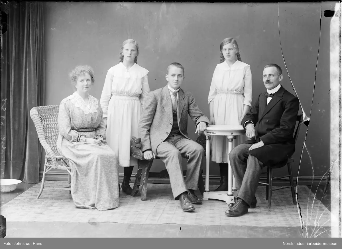Gruppeportrett av sogneprest Urbye og familen, en kvinne og to menn sittende på stoler, to jenter stående bak dem.