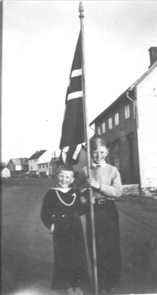 To brødre med stort flagg i Borkenes sentrum.