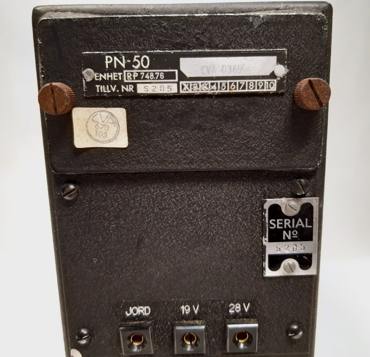 Spänningsstabilisator, RP 748.76 till Radarstation PN-50/A. Bestående av en svart låda i metall med manöverpanel på ena sidan. Panelen försedd med ett numrerat vred, tre stick-kontakter, samt ett bärhandtag.