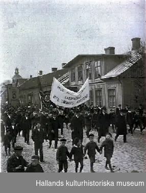 Demonstration 1:a maj. "Årlig... Lagstadgad åtta timmars arbetsdag". Fototid (osäker) 1910-tal. Möjligen Torggatan Varberg.