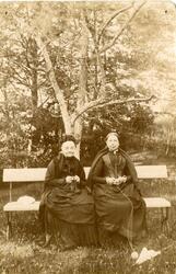 Eldre kvinne og Dikka Rømer med med strikketøy på en benk i 
