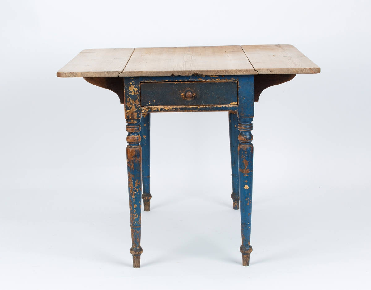 Klaffebord med trehvit plate, to klaffer og en skuff. Blåmalte ben. Kvadratisk med oppslåtte klaffer.