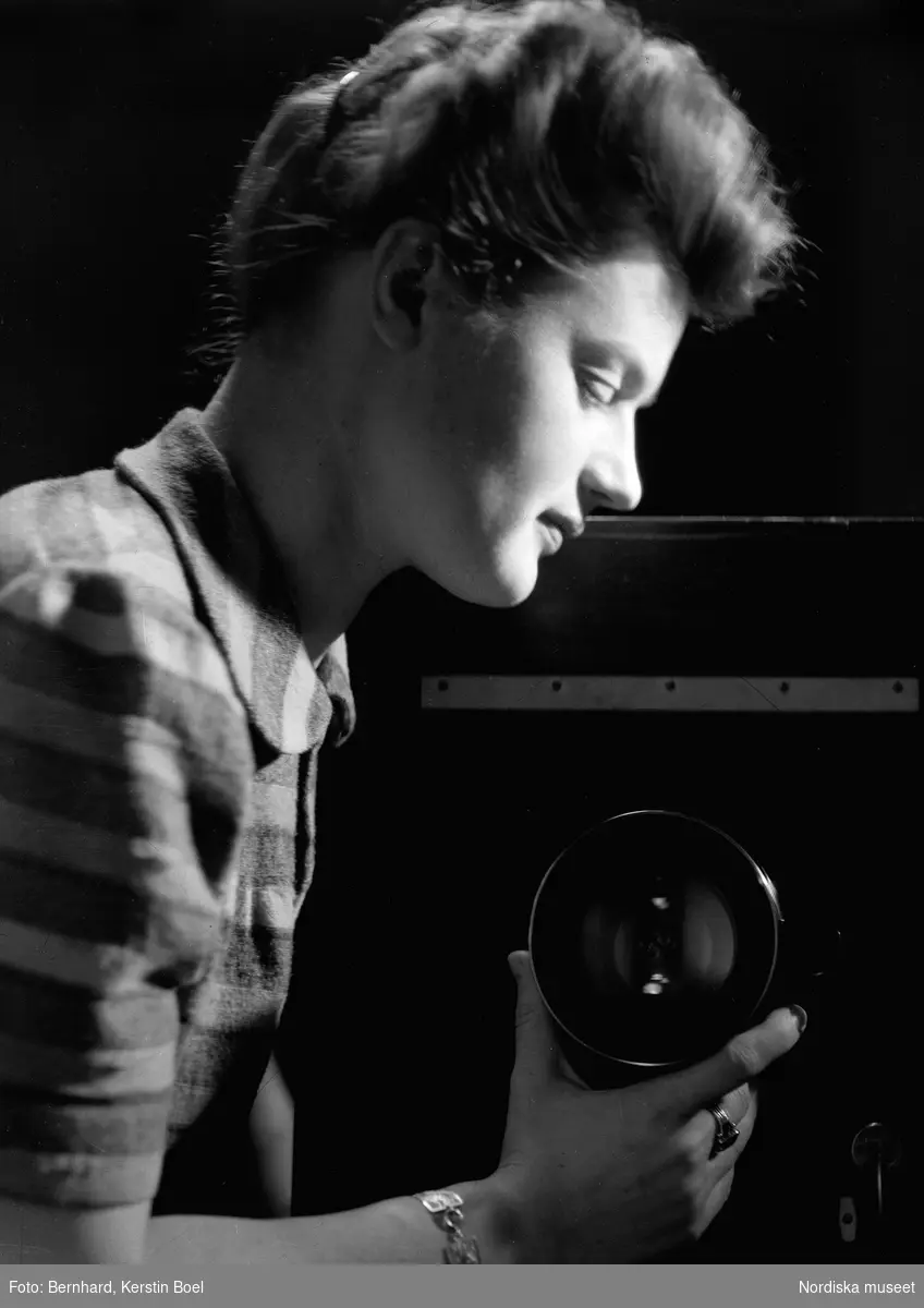 Fotografen Kerstin Bernhard ställer in objektivet på en lådkamera i sin ateljé. Självporträtt.