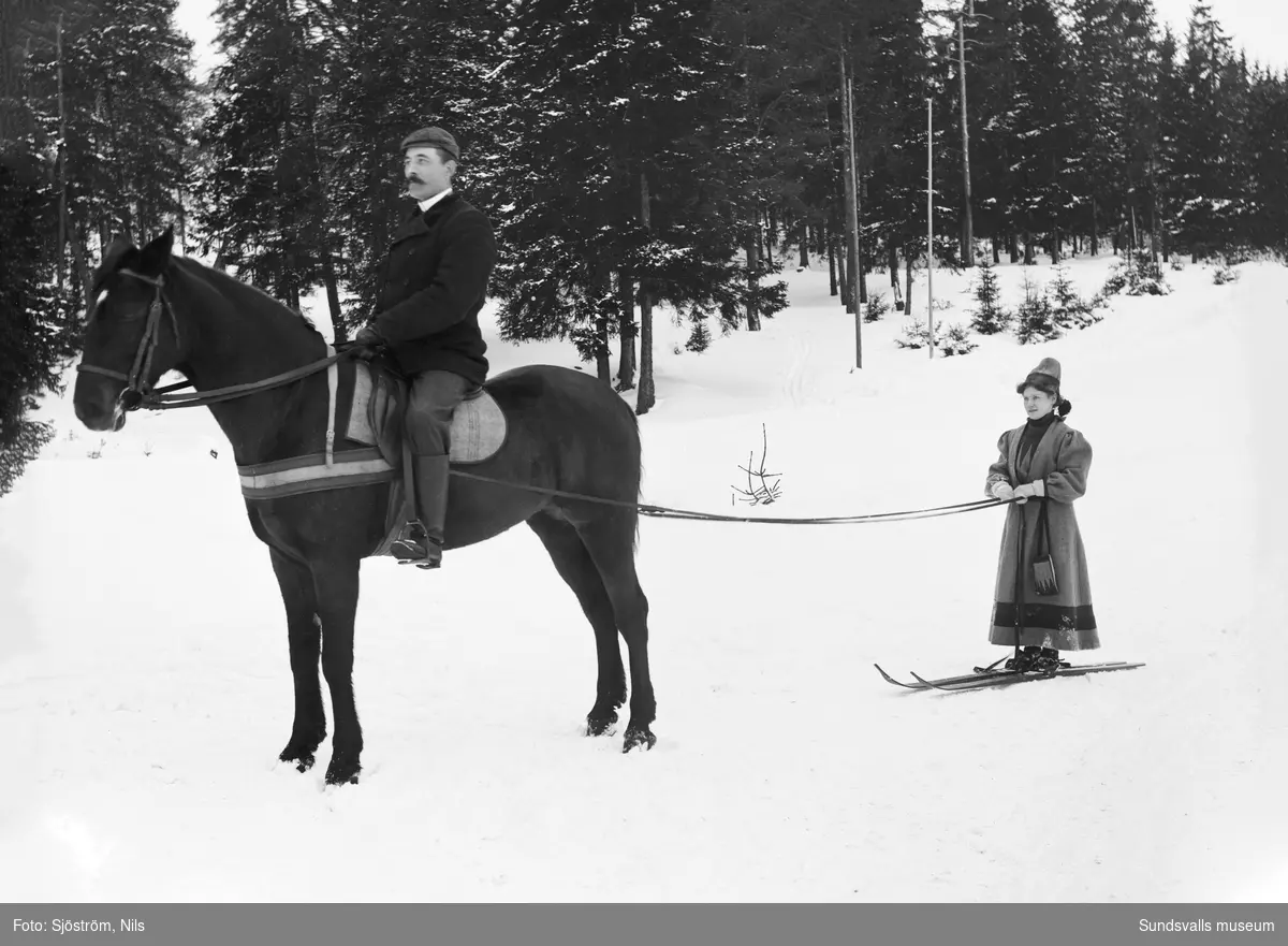 Disponenten vid Svartvik, J C Barth till häst medan hans hustru Marianne tolkar på skidor bakom hästen.